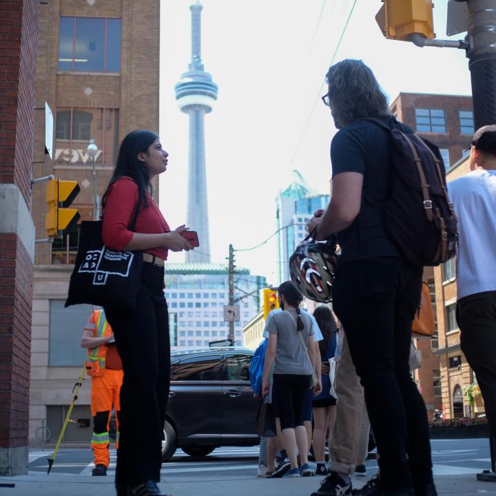 Graduates standing outside, chatting in front of CN tower.