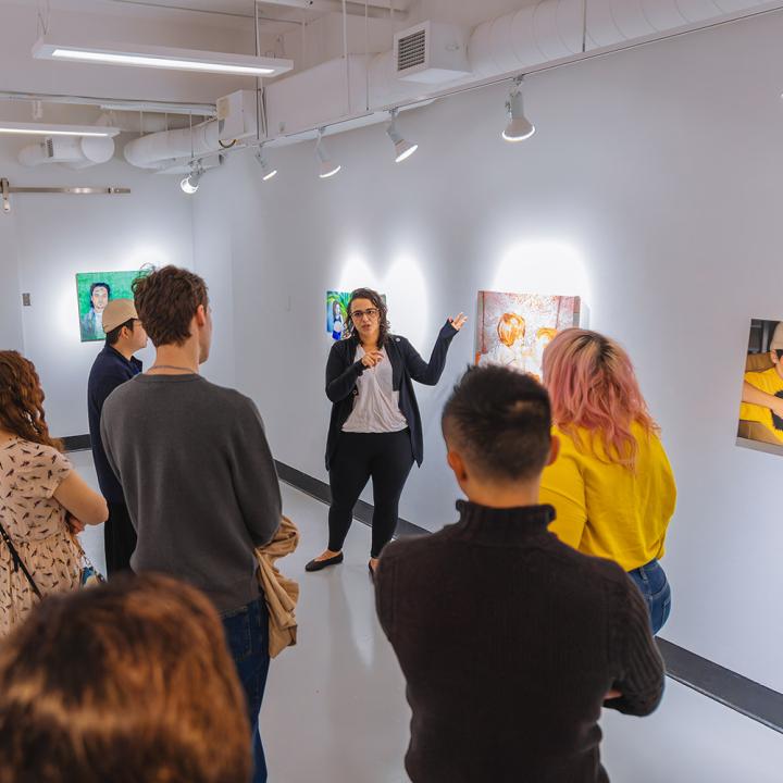 People in a gallery listening to a curator presentation
