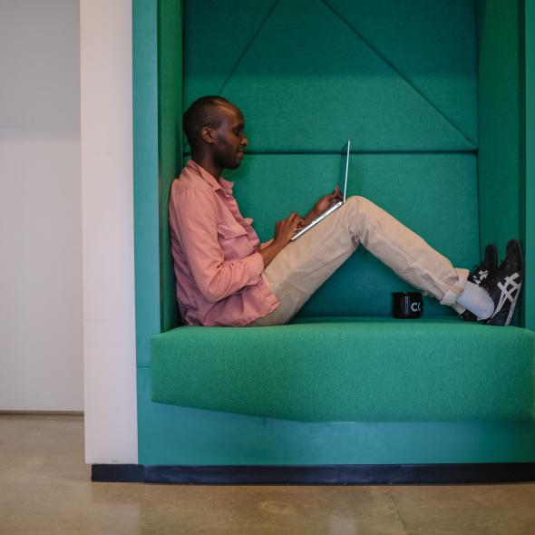 Graduate student sitting in work booth, on laptop